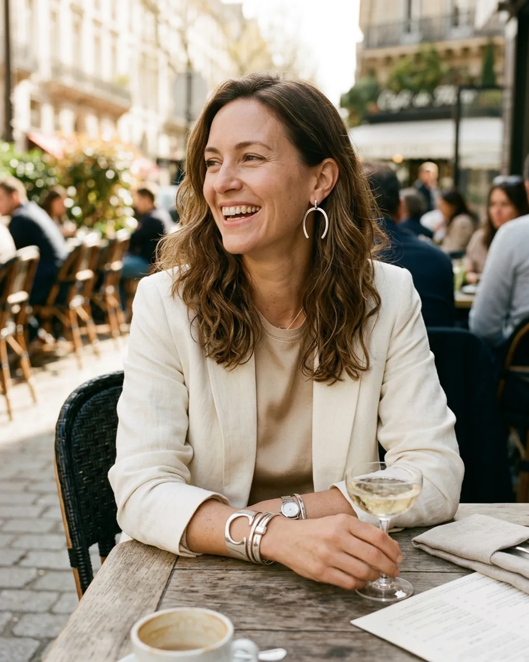Woman wearing cuff and hoop earrings at an outdoor cafe